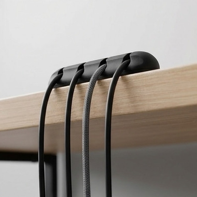 Organizador de cables ERGORA — detalle en el borde de la mesa